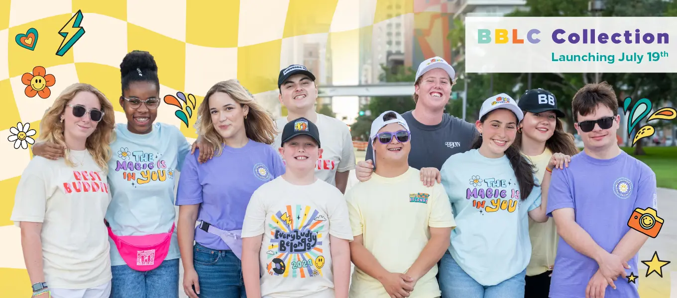 "A diverse group of smiling individuals wearing Best Buddies-themed apparel, posing outdoors with a colorful yellow checkered background. Text reads 'BBLC Collection Launching July 19th,' surrounded by playful graphic elements like flowers, hearts, and stars.