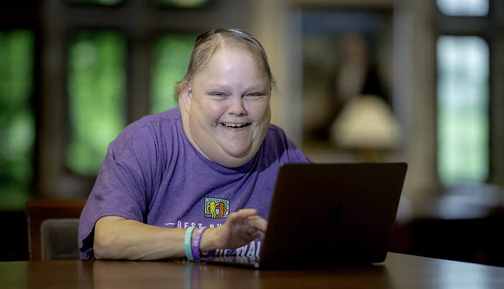 Kendra holden smiling at a computer