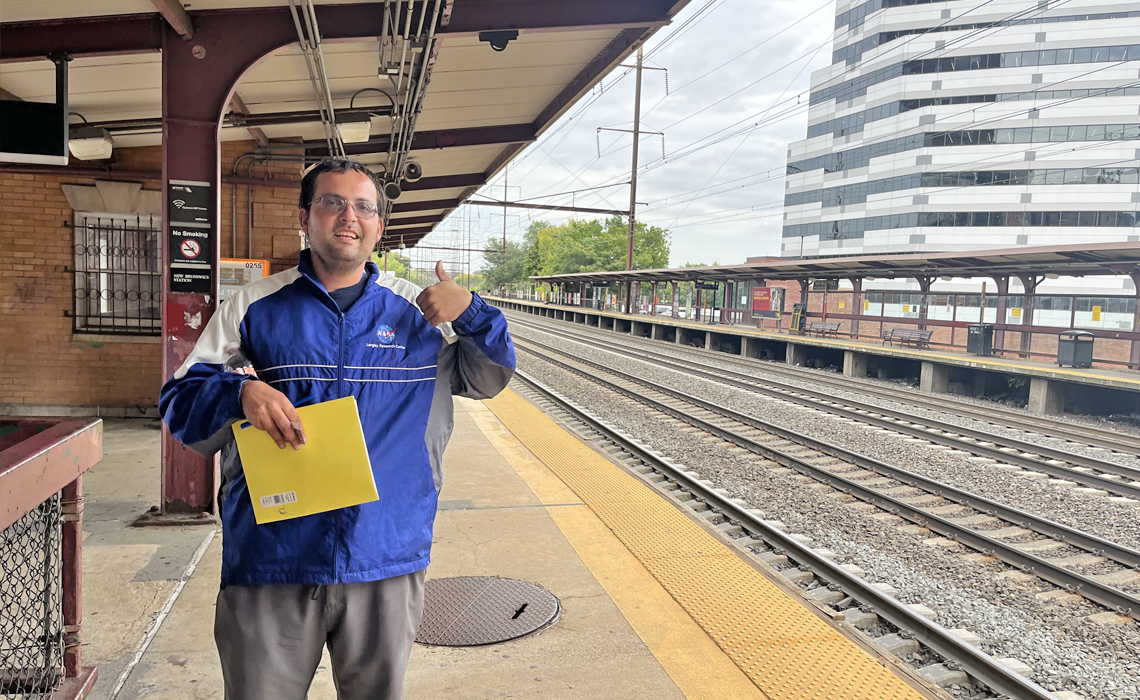 Alex giving a thumbs up in front of the train track near his apartment in New Brunswick.